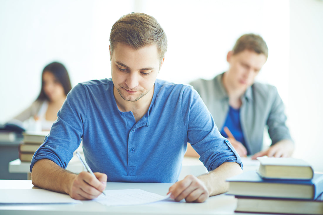 Aula de examen con opositores realizando una prueba tipo test