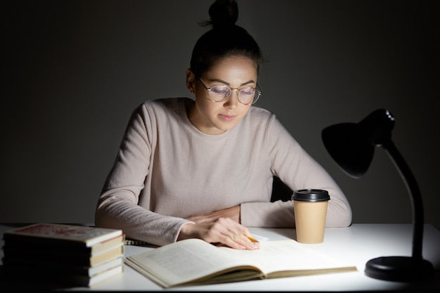 Persona estudiando de noche con una lámpara de mesa representando las horas diarias dedicadas al TAI