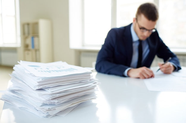 Pila de documentos administrativos representando expedientes y bolsas de empleo público