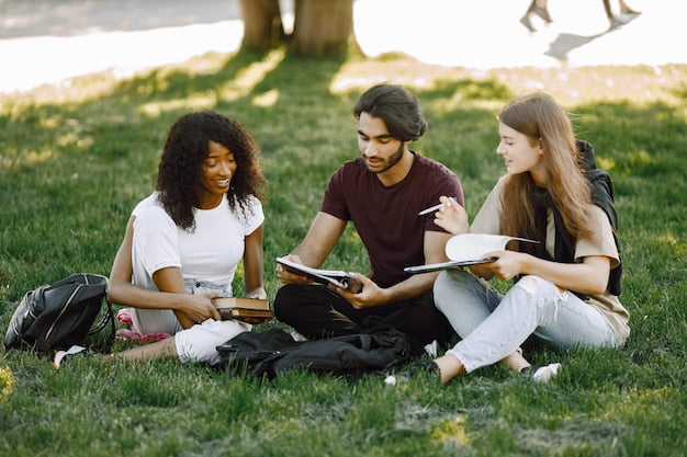 Grupo de estudiantes universitarios hablando en el campus sobre compaginar estudios y oposición