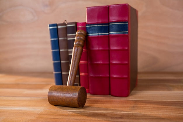Mazo de juez junto a libros de leyes, representando el estudio de normativa para el TAI