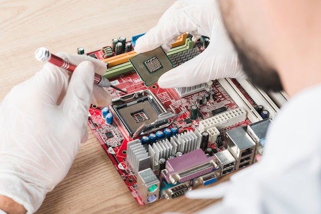 Técnico insertando un chip en la placa base de un ordenador sobre una mesa de madera