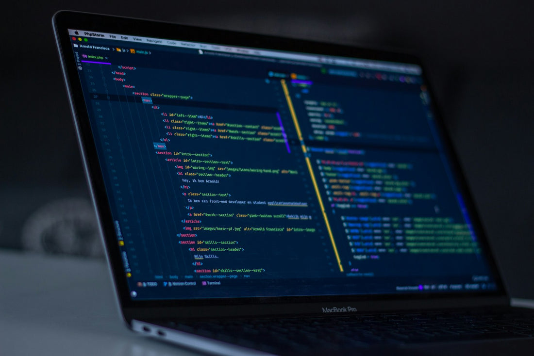 Portátil encendido mostrando código en pantalla, representando la administración de sistemas operativos
