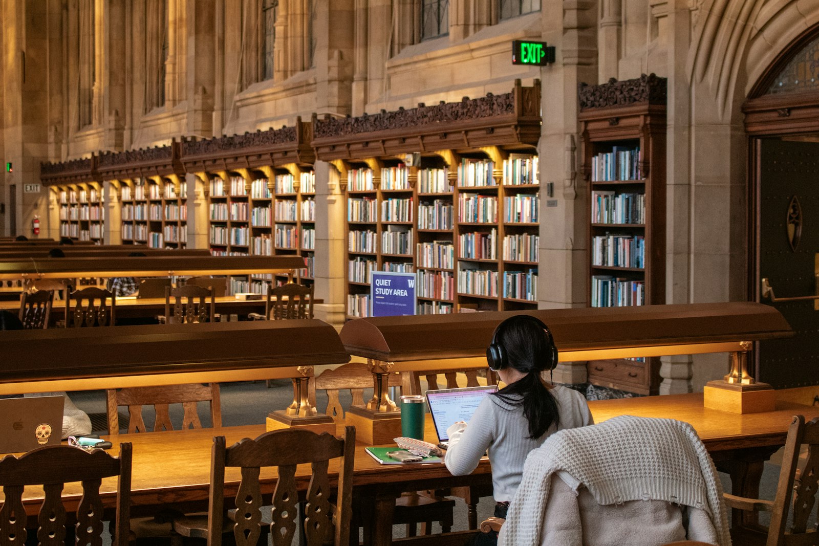 Persona estudiando en una biblioteca, preparando de nuevo el examen del TAI para una nueva convocatoria
