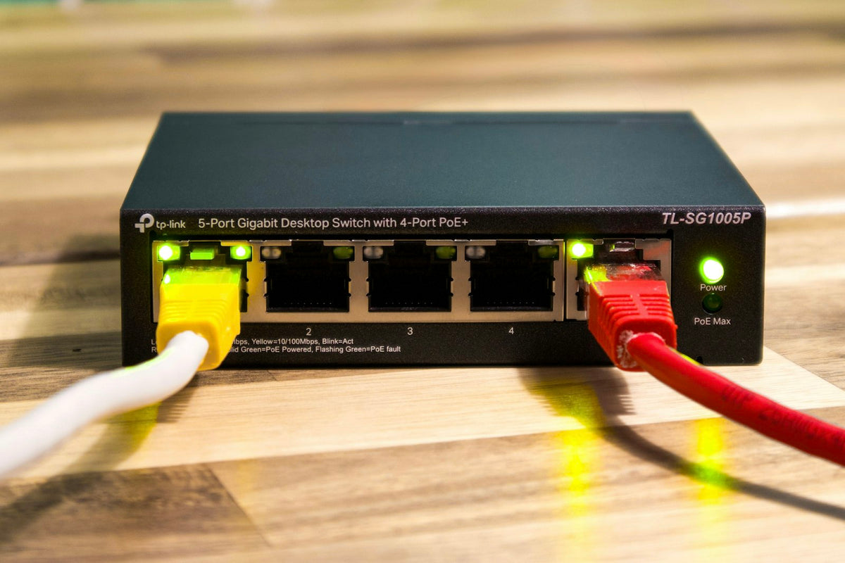 Switch de red con cables ethernet conectados, representando las redes inalámbricas del Bloque IV del TAI