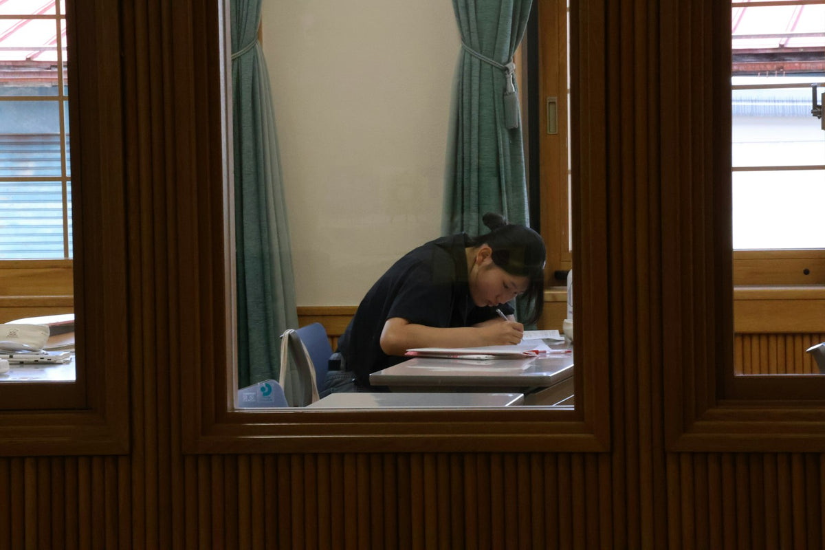 Persona repasando apuntes con libros abiertos en una mesa de estudio, imagen de portada sobre un mes preparando el TAI