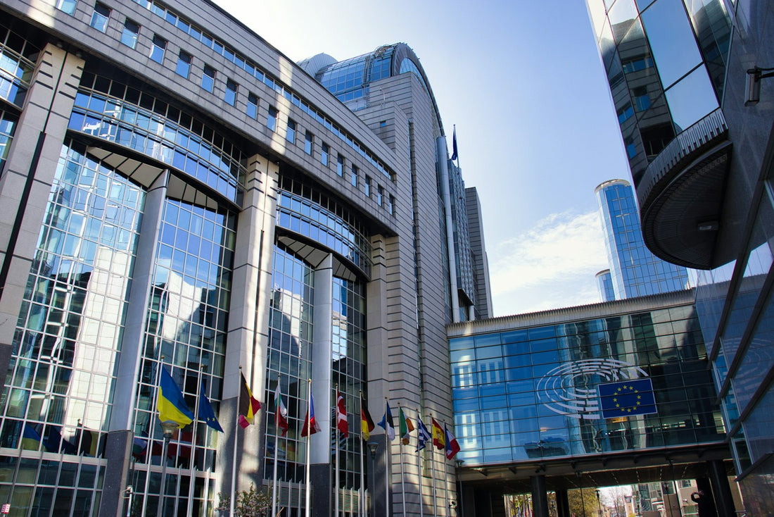 Edificio del Parlamento Europeo con banderas de la Unión Europea ondeando
