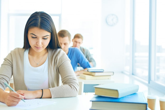 Fila de personas realizando un examen en un aula